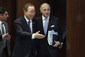 UN Secretary General Ban Ki-moon, left, escorts France's Foreign Minister Laurent Fabius to their meeting at the United Nations, Friday, Dec. 18, 2015.