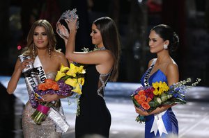 Former Miss Universe Paulina Vega, center, removes the crown from Miss Colombia Ariadna Gutierrez, left, before giving it to Miss Philippines Pia Alonzo Wurtzbach, right, at the Miss Universe pageant on Sunday, Dec. 20, 2015, in Las Vegas.