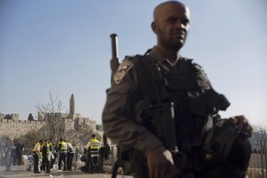 An Israeli police officer stands guard at the site as others work after a Palestinian assailant stabbed Israelis outside Jerusalem’s Old City, Wednesday, Dec. 23, 2015.