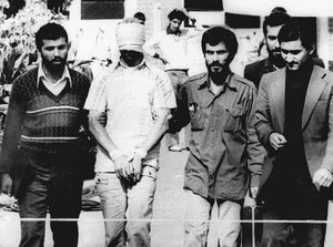 In this Nov. 9, 1979, file photo, one of the hostages being held at the U.S. Embassy in Tehran is displayed to the crowd, blindfolded and with his hands bound, outside the embassy.