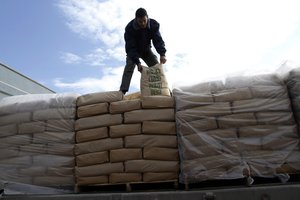 A Palestinian worker adjusts bags of cement loaded on a truck that entered the Gaza Strip from Israel through the Kerem Shalom crossing in Rafah in the southern Gaza Strip.