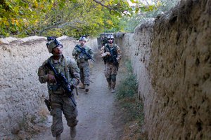 File - U.S., Czech and Afghan soldiers patrol and clear routes through a village in Parwan province, Afghanistan, Oct. 20, 2015.