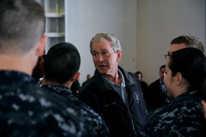 Former President George W. Bush shakes hands with Sailors following a promotion and reenlistment ceremony aboard the aircraft carrier USS George H.W. Bush