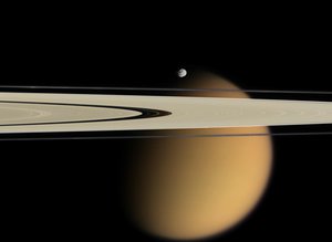 2007/10/15 Titan Beyond the Rings - Cassini delivers this stunning vista showing small, battered Epimetheus  and smog-enshrouded Titan, with Saturn&acute;s A and F rings stretching across  the scene.     The color information in the colorized view is comp