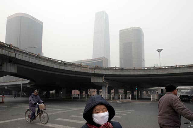 A pedestrian wearing a protective mask in Beijing, Jan. 17, 2012. Decades of coal-powered industrialization combined with the government-promoted car craze have brought China the worst air pollution in the world. (Photo: Gilles Sabrie/The New York Times)