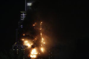 Smoke and flames pouring from a residential building, which also contains the Address Downtown Hotel, in Dubai, United Arab Emirates, Thursday evening, Dec. 31, 2015.