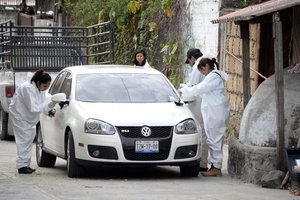 Forensic investigators inspect a car outside the home where Gisela Mota was killed, one day after taking office as mayor, in Temixco, Morelos State, Mexico, Saturday, Jan. 2, 2016.