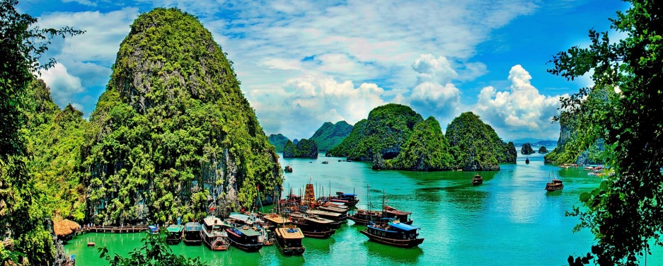 The ships floats in a sea gulf surrounded with high mountains and direct rocks