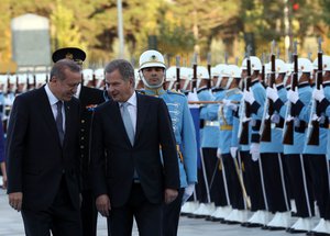 Finland's President Sauli Niinisto, right, and his Turkish counterpart Recep Tayyip Erdogan speak as they inspect a military honour guard in Ankara, Turkey, Tuesday, Oct. 13, 2015.