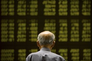 A Chinese investor monitors stock prices at a brokerage house in Beijing, Tuesday, Aug. 18, 2015.