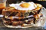 Adam Liaw's huge meat-filled toasted sandwich monster is topped with egg and cheese and smothered in a beer-based sauce.