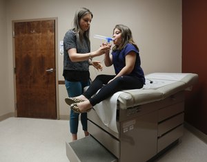 In this Friday, May 1, 2015 photo, physician assistant Kristin Suchowiecki administers a nebulizer treatment on patient Jaylin Colon, 9, at Albany Med EmUrgentCare on Friday, May 1, 2015, in Coxsackie, N.Y.