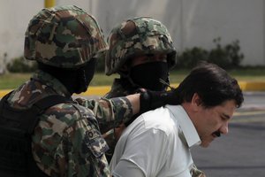 FILE - In this Feb. 22, 2014, file photo, Joaquin "El Chapo" Guzman, in handcuffs, is escorted to a helicopter by Mexican navy marines in Mexico City, Mexico. Mexico's security commission has announced early Sunday July 12, 2015 that Guzman has escaped from a maximum security prison for the second time.