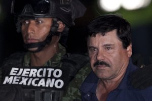 Mexican drug lord Joaquin "El Chapo" Guzman, right, is escorted by soldiers and marines to a waiting helicopter, at a federal hangar in Mexico City, Friday, Jan. 8, 2016.