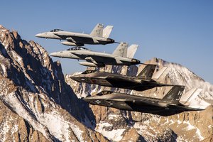 File - Two F-35C Lightning II aircraft fly in formation over the Sierra Nevada mountain range with two F/A-18E/F Super Hornets from Naval Air Station (NAS) Lemoore, during a six-day visit by the Grim Reapers of Strike Fighter Squadron.