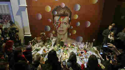 People pay tribute to British singer David Bowie in front of a mural by artist Jimmy C in London on Jan. 11.