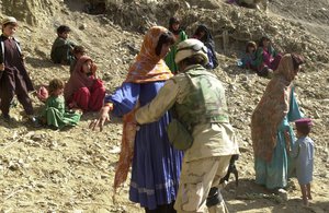 After finding a woman hiding a Russion AK-47 machine gun, U.S. Army Sgt. Nicola Hall from Atlanta, Georgia, frisks women Sunday, Sept. 29, 2002, in the southeastern Afghanistan village of Masi Kalay near the Pakistan border.