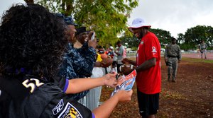 Joint Base Pearl Harbor-Hickam service members and their families’ take pictures and get football memorabilia signed by National Football League Pro Bowl player Antonio Cromartie of the New York Jets and others players at Earhart Field, JBPHH, Hawaii, Jan. 24, 2013.