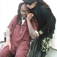 Mumia’s wife, Wadiya Jamal, hugs him during a visit on April 9, 2015. This photo shows the terrible, “elephant-skin” rash on his arms.