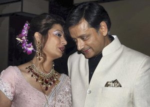 FILE – In this Sept. 4, 2010 file photo, former Indian Junior Foreign Minister Shashi Tharoor listens to his wife Sunanda Pushkar at their wedding reception in New Delhi, India.