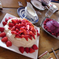 A table with a Xmas summer dessert feast: pavlova with strawberries and a berry sorbet pudding