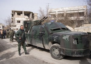 Syrian soldiers stand at a pickup truck with a gun mounted on top in Salma, Syria, Friday, Jan. 22, 2016.