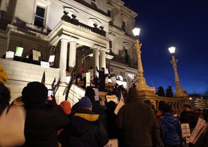 Protesters gather outside the state Capitol before Michigan Gov. Rick Snyder's State of the State address, Tuesday, Jan. 19, 2016, in Lansing, Mich.