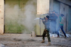 In this Wednesday, Oct. 29, 2014 file photo, Libyan military soldiers fire their weapons during clashes with Islamic militias in Benghazi.