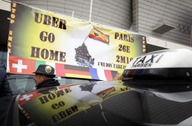 Taxi drivers on strike stand next to their cars as they demonstrate in Paris on Tuesday.