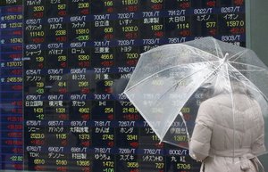 A woman looks at an electronic stock board at a securities firm in Tokyo, Friday, Jan. 29, 2016. Tokyo stocks finished nearly 3 percent higher on Friday while the yen dived as the country's central bank introduced a negative interest rate policy to boost the economy after previous stimulus efforts produced indifferent results.