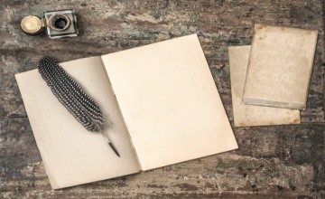 Open book, vintage writing tools feather pen and inkwell