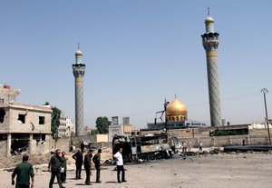 This June 14, 2012, file photo shows Syrian security forces at the site where a car bomb exploded near the shrine of Sayyida Zeinab, visible in the background, in a suburb of Damascus, Syria.