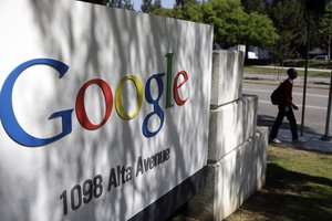 File- In this June 5, 2014 file photo, a man walks past a Google sign at the company's headquarters in Mountain View, Calif.