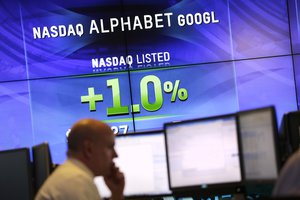 Electronic screens post the price of Alphabet stock, Monday, Feb. 1, 2016, at the Nasdaq MarketSite in New York.