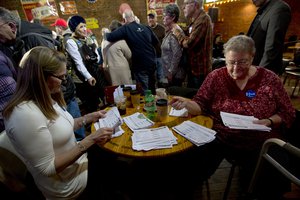 In this Jan. 25, 2016, photo, volunteers sort through commitment to caucus for Democratic presidential candidate Hillary Clinton cards during a campaign event at the Smokey Row in Oskaloosa, Iowa.