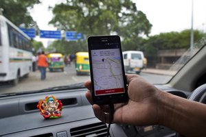 An Indian cab driver displays the city map on a smartphone provided by Uber as he drives in New Delhi, India, Friday, July 31, 2015.