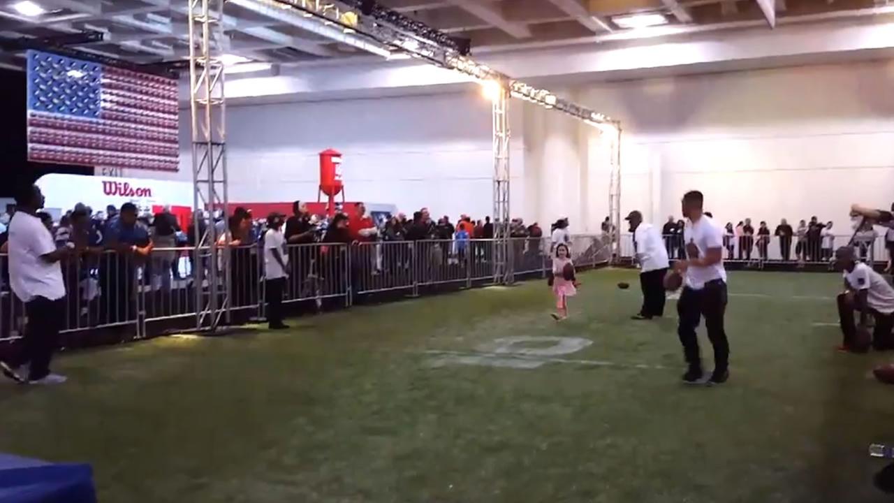 A little girl practices drills at NFL Experience in San Francisco on Saturday, February 6, 2016.