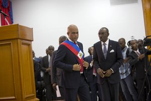 Haiti's President Michel Martelly talks to Prime Minister Evans Paul after his speech to lawmakers in Port-au-Prince, Haiti, Sunday, Feb. 7, 2016.