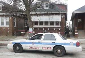 Crime scene tape surrounds a home Friday, Feb. 5, 2016, in Chicago with a Police Department vehicle parked in foreground.