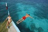 A tourist takes a dive from a dhoni boat.
