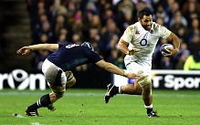 Billy Vunipola strides past Scotland's David Denton at Murrayfield