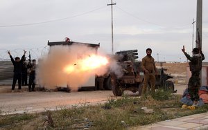 File - Imam Ali Brigades, members of of an Iraqi Shiite militant group, launch rockets against Islamic State extremist positions during clashes in Tikrit, 130 kilometers (80 miles) north of Baghdad, Iraq, Tuesday, March 24, 2015.