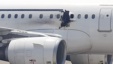 A gaping hole is visible in the side of a plane operated by Daallo Airlines as it sits on the runway of the airport in Mogadishu, Somalia, Feb. 2, 2016. 