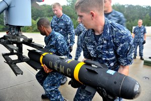 File - Aviation Ordnancemen place a Hellfire missile to their helicopter in preparation for a live-fire training mission in Norfolk; Virginia, 21 September, 2011.