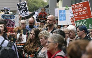 Protestors hold signs up during a rally to protest against asylum seekers being deported in Sydney, Australia, Thursday, Feb. 4, 2016.