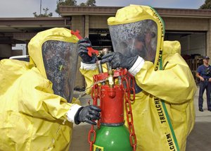 Paul Smith and Ron Larsen secure a simulated leak on a chlorine bottle during a training exercise.