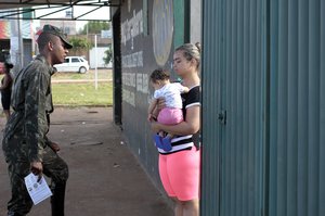 File - A Brazilian soldier talks with a young mother holding her baby  during an awareness campaign on combating the Aedes aegypti mosquito and the Zika virus it carries.