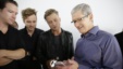 Apple CEO Tim Cook, right, looks at the new iPhone 6s with the members of OneRepublic, in the demo room after Apple event at the Bill Graham Civic Auditorium in San Francisco, Sept. 9, 2015. 