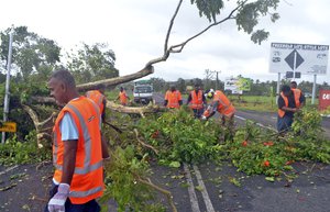 Road workers remove a fallen tree blocking a road near Lami, Fiji, Sunday, Feb. 21, 2016, after cyclone Winston ripped through the country. Officials in Fiji are assessing damage in the wake of a ferocious cyclone that tore through the Pacific island chain.