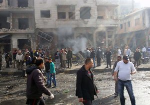 In this photo released by the Syrian official news agency SANA, Syrian citizens gather at the scene where two blasts exploded in the pro-government neighborhood of Zahraa, in Homs province, Syria, Sunday, Feb. 21, 2016.